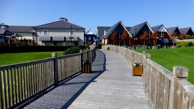 A boardwalk beside modern timber clad buildings on the edge of Kildare town