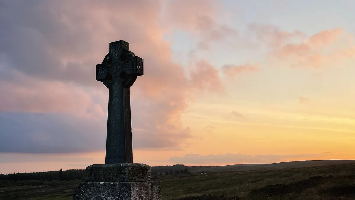 A stone high cross against the sunset on Sliabh Beagh, County Monaghan