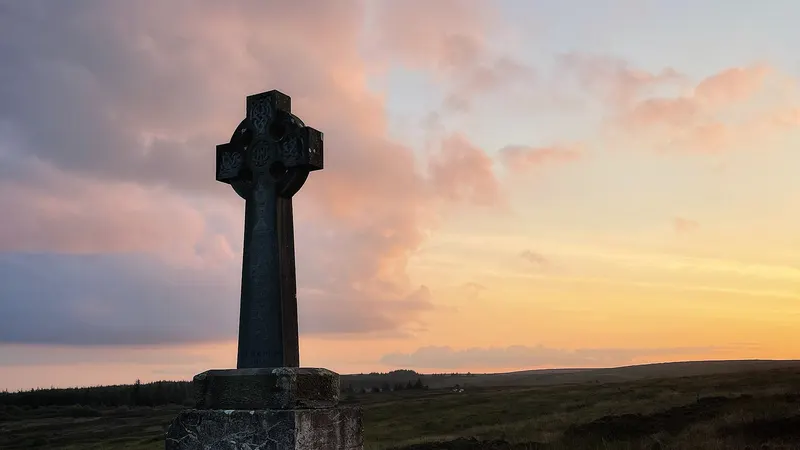 A stone high cross against the sunset on Sliabh Beagh, County Monaghan