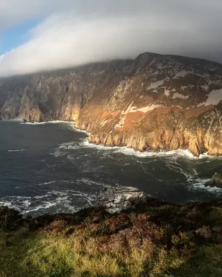 Sunlight on the sea cliffs at Sliabh Liag with the Atlantic dark below them