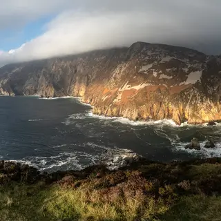 Sunlight on the sea cliffs at Sliabh Liag with the Atlantic dark below them