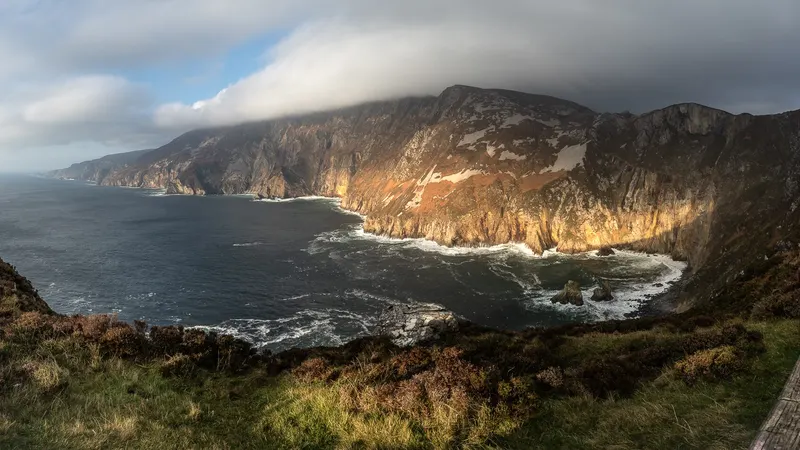 Sunlight on the sea cliffs at Sliabh Liag with the Atlantic dark below them