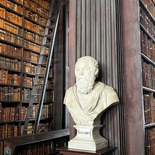 A marble bust between the bookshelves of the Long Room at Trinity College