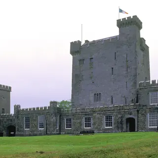 The tower house and castellated outer wall at Knappogue Castle above its lawn