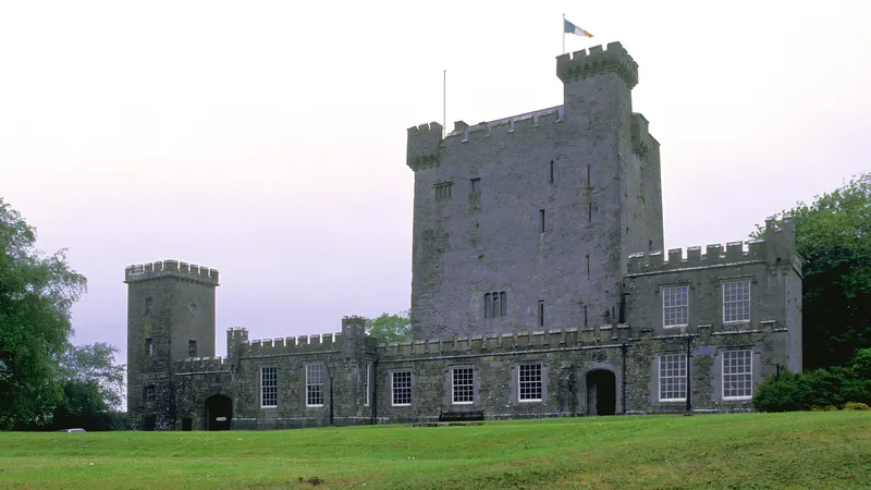 The tower house and castellated outer wall at Knappogue Castle above its lawn