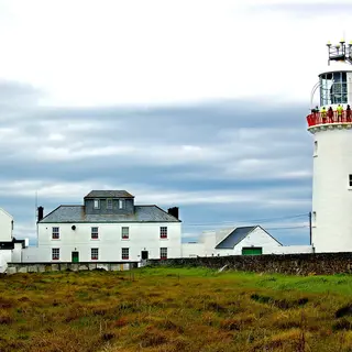 The white tower of Loop Head Lighthouse and the keepers' houses on the headland