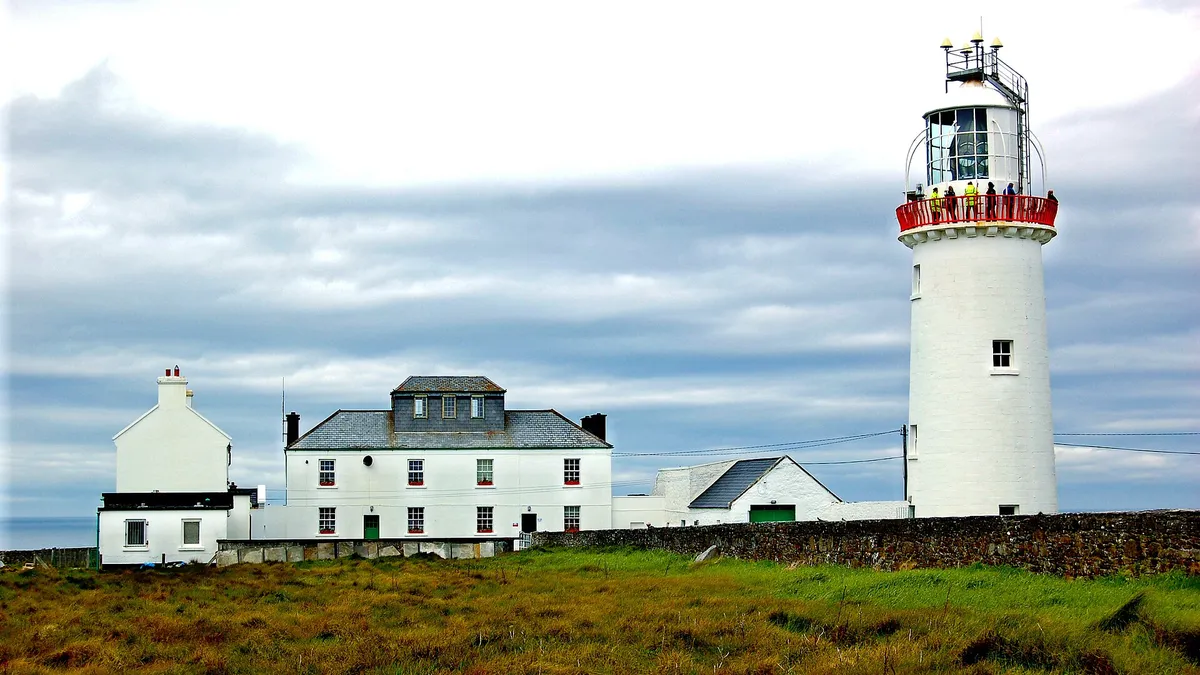 The white tower of Loop Head Lighthouse and the keepers' houses on the headland