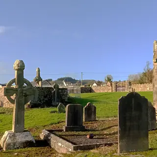 Two high crosses standing among headstones in the graveyard at Kilkieran