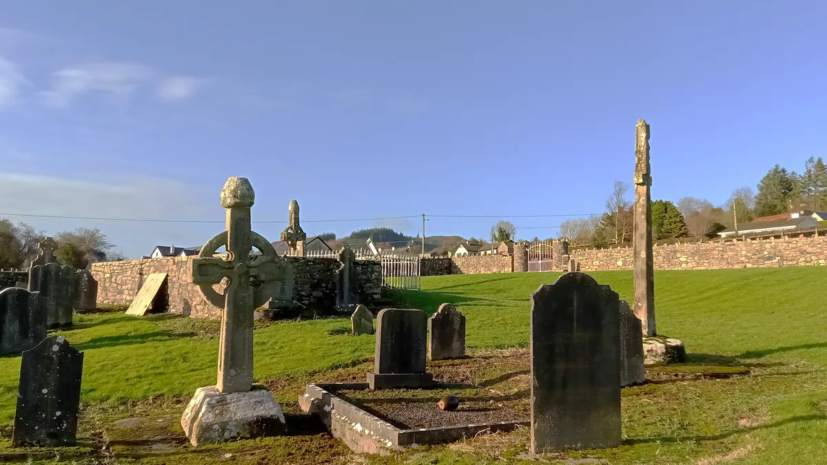 Two high crosses standing among headstones in the graveyard at Kilkieran