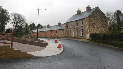 New stone paving and kerbs along the street of houses at Mullan Village