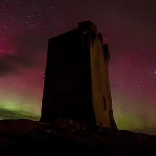 The northern lights over the signal tower at Banba's Crown, Malin Head