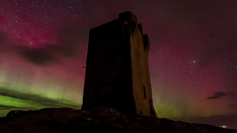 The northern lights over the signal tower at Banba's Crown, Malin Head