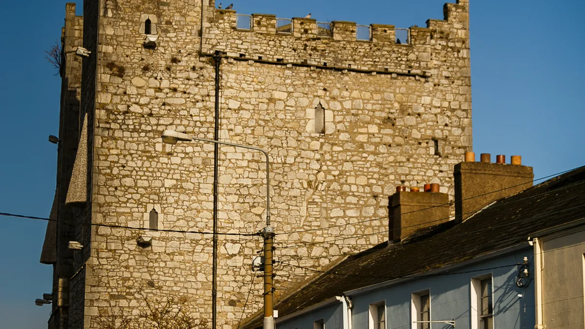 The battlemented tower of Ardee Castle rising above the roofs of the street