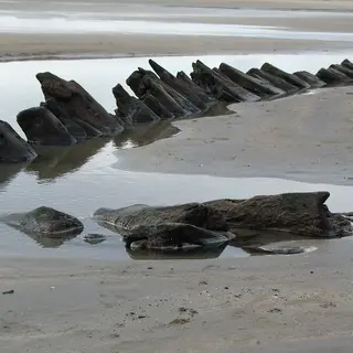 Angled rock ledges running out across the wet sand at Streedagh