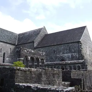 The stone nave and transept of Ballintubber Abbey above its graveyard