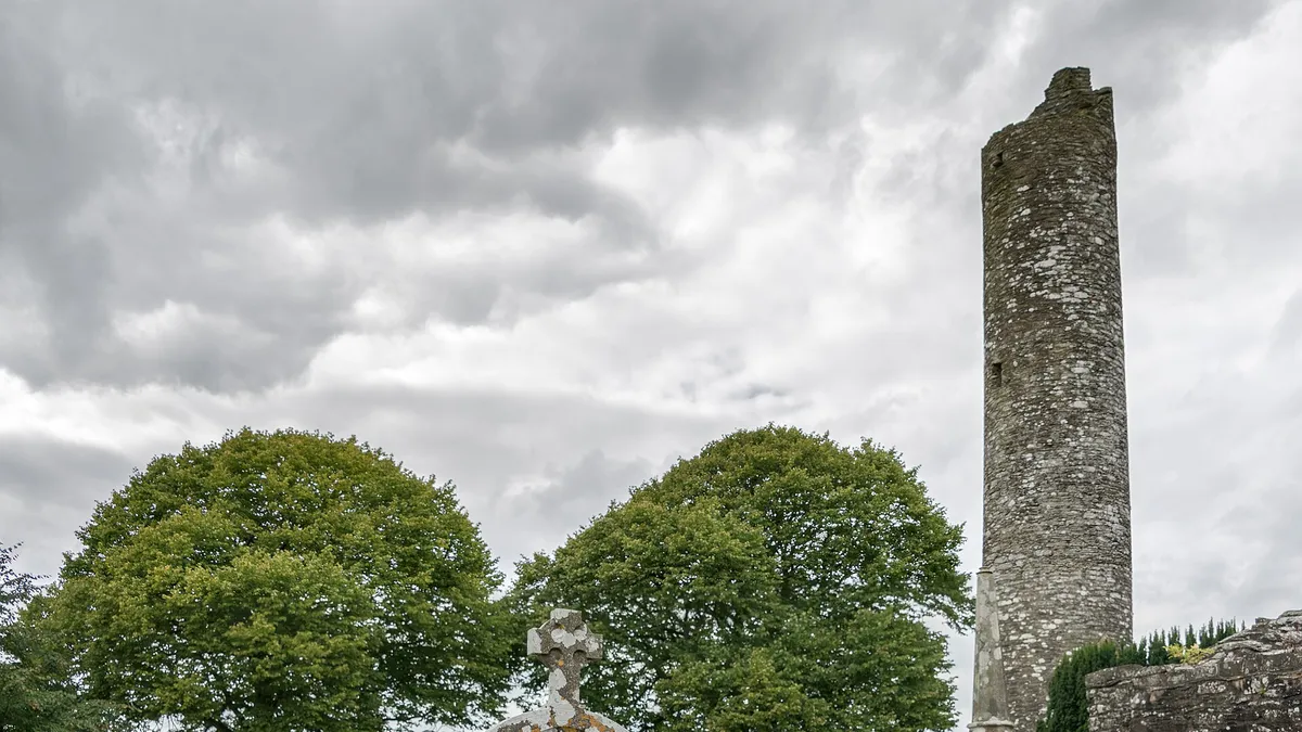 The round tower at Monasterboice standing above the trees