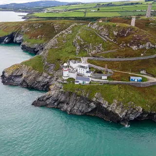 Wicklow Head and its lighthouses seen from the air with the road winding out along the headland