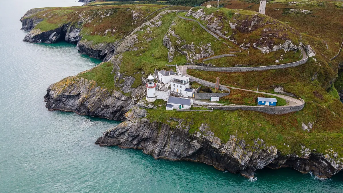 Wicklow Head and its lighthouses seen from the air with the road winding out along the headland