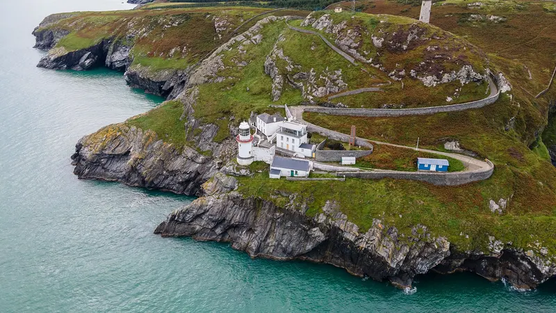 Wicklow Head and its lighthouses seen from the air with the road winding out along the headland