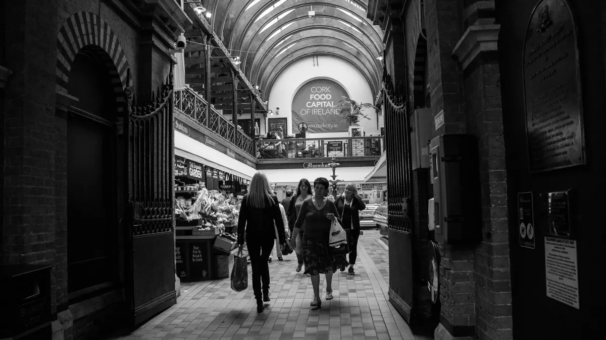 Shoppers walking under the arched roof of the English Market in Cork city