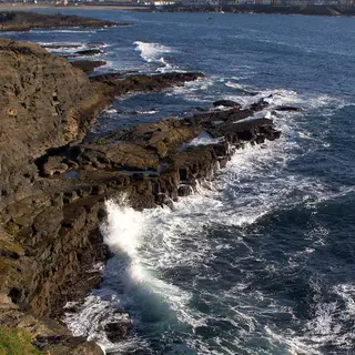 Waves breaking against the dark cliffs at Kilkee