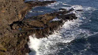 Waves breaking against the dark cliffs at Kilkee