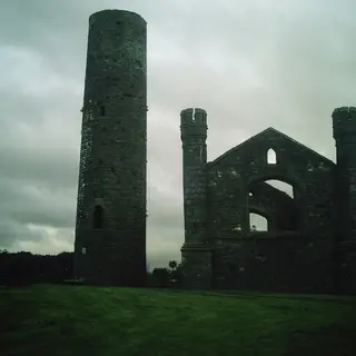 The round tower at Taghadoe standing beside the gable of the ruined church