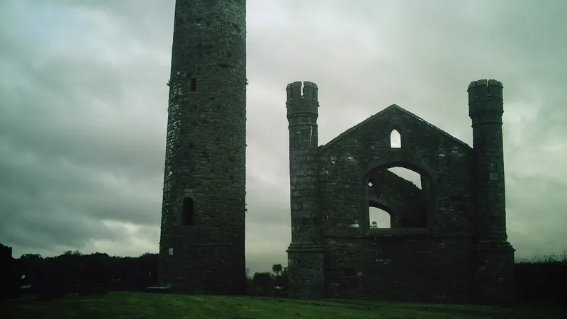 The round tower at Taghadoe standing beside the gable of the ruined church