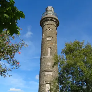 The tall round tower of the Spire of Lloyd seen through the branches of a tree