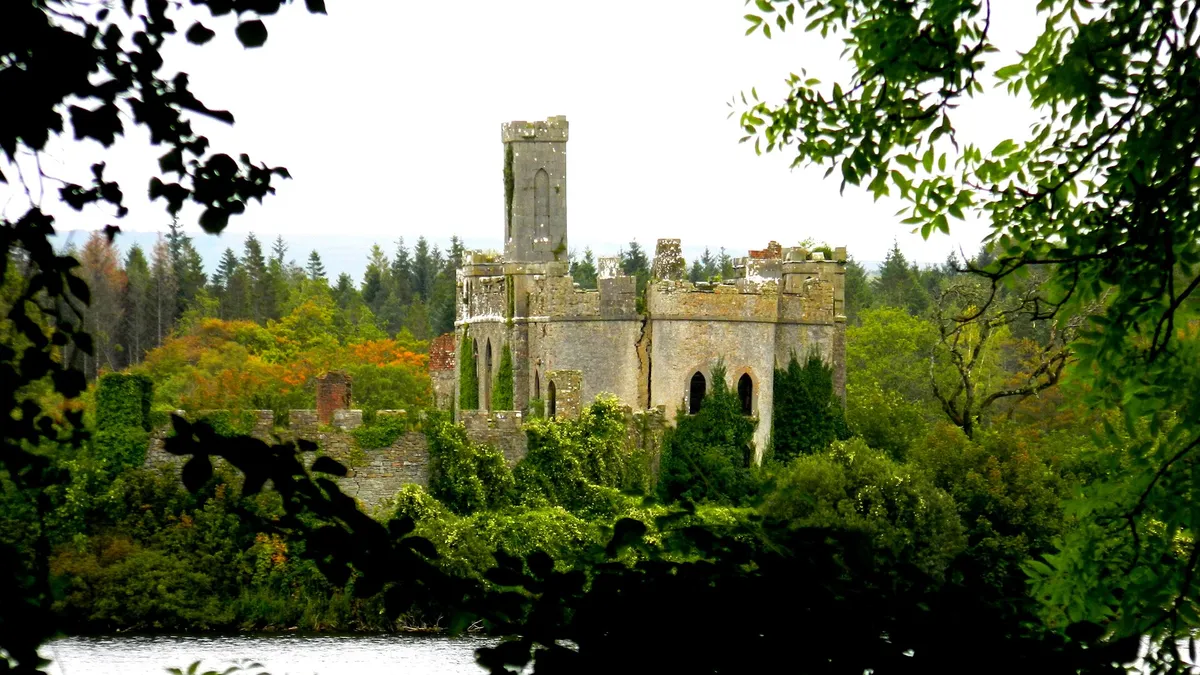 The castle on Castle Island in Lough Key seen through the trees from the shore