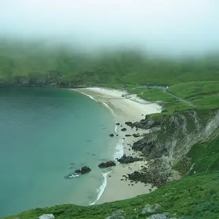 The curve of sand at Keel with the cliffs running away behind it