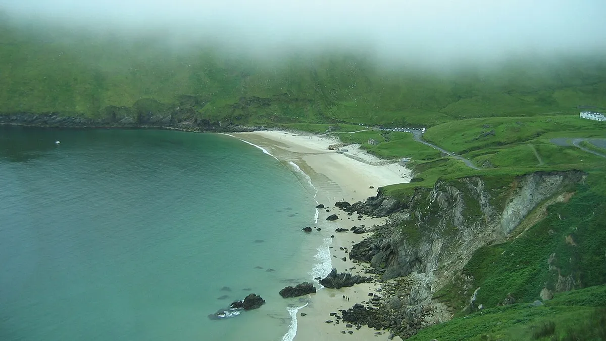 The curve of sand at Keel with the cliffs running away behind it