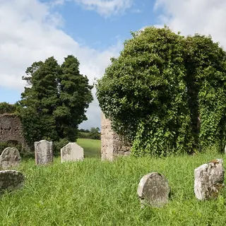 Headstones and the ivied ruin of the old church at Errigal Truagh
