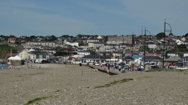 The wide flat strand at Tramore with the town rising behind it