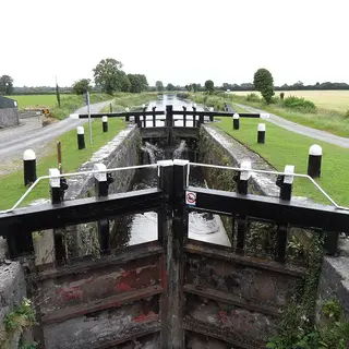 A canal lock with its black and white gates closed on the Grand Canal