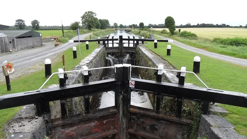 A canal lock with its black and white gates closed on the Grand Canal