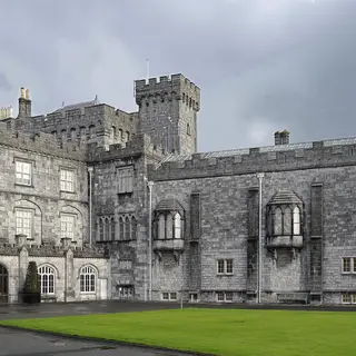 The long stone front of Kilkenny Castle across the lawn of its courtyard