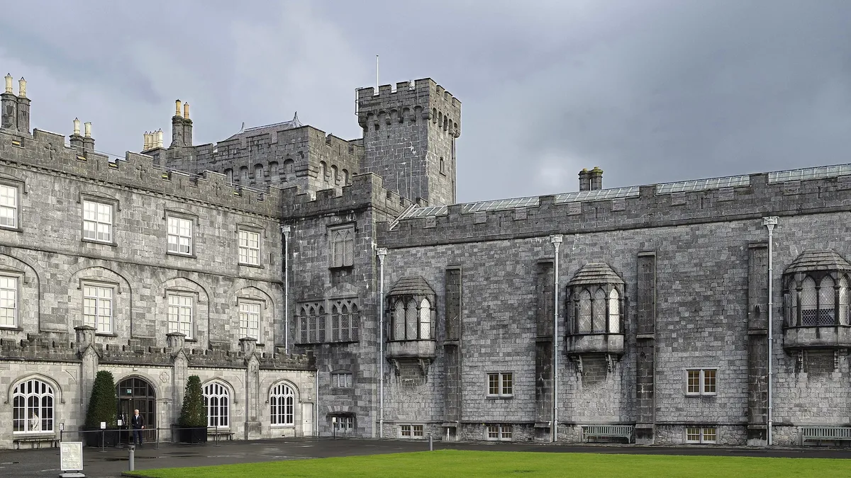 The long stone front of Kilkenny Castle across the lawn of its courtyard