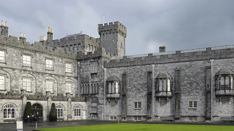 The long stone front of Kilkenny Castle across the lawn of its courtyard