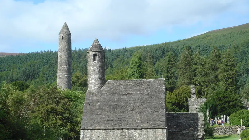 The round tower and church at Glendalough among the trees