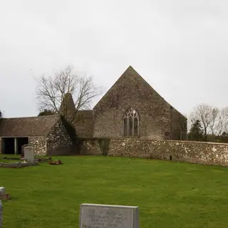 The high gable and long nave of Aghaboe Abbey with its graveyard in front