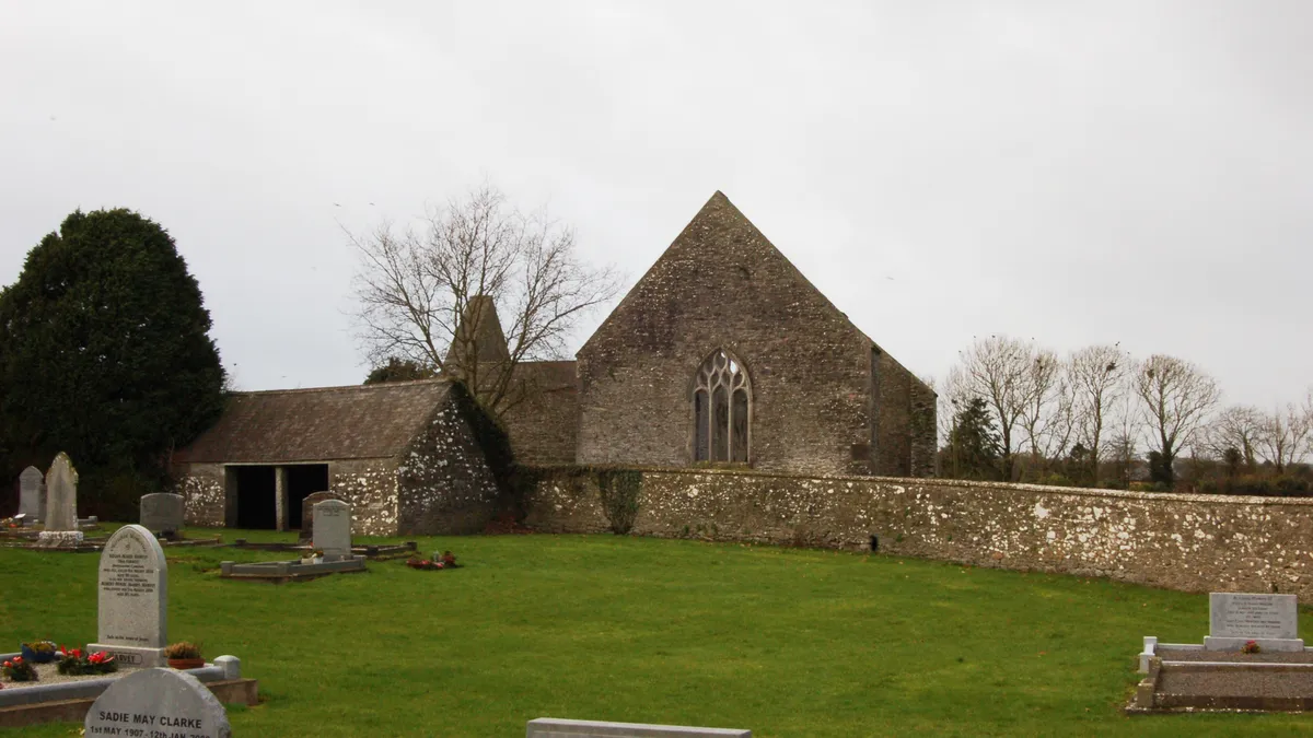 The high gable and long nave of Aghaboe Abbey with its graveyard in front