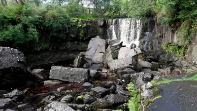 Water falling over a rock ledge into the pool at Tullydermot Falls