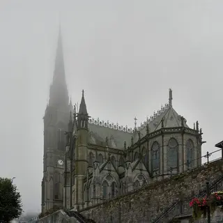 The spire and side of Saint Colman's Cathedral in Cobh in low cloud