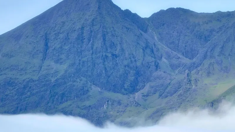 Cloud sitting on the MacGillycuddy's Reeks above green fields