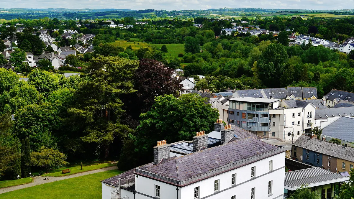 Kilkenny rooftops and trees looking out over the countryside from St Canice's round tower