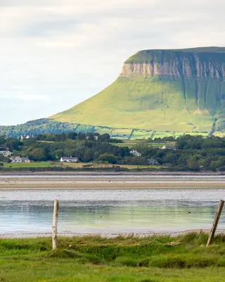 The flat top and steep face of Benbulben above the fields and the estuary