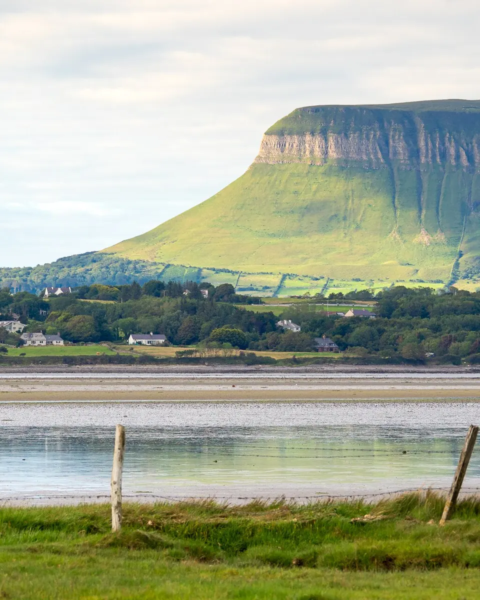 The flat top and steep face of Benbulben above the fields and the estuary