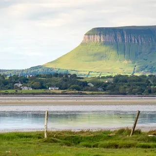 The flat top and steep face of Benbulben above the fields and the estuary