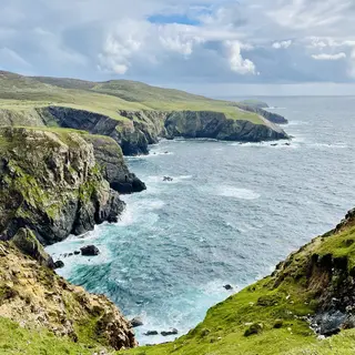 Cliffs and inlets along the shore of Arranmore with Atlantic swell breaking below
